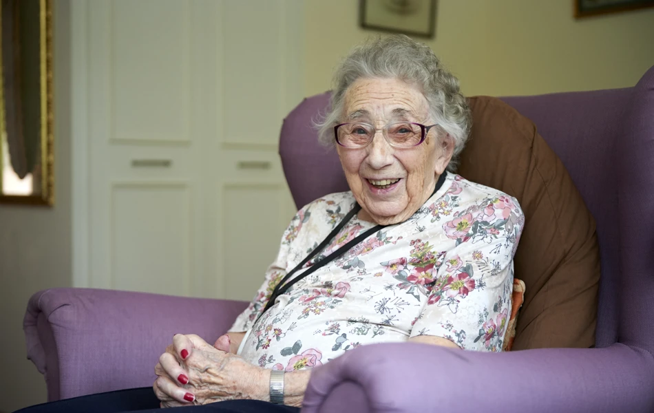 Smiling, happy resident sitting in armchair