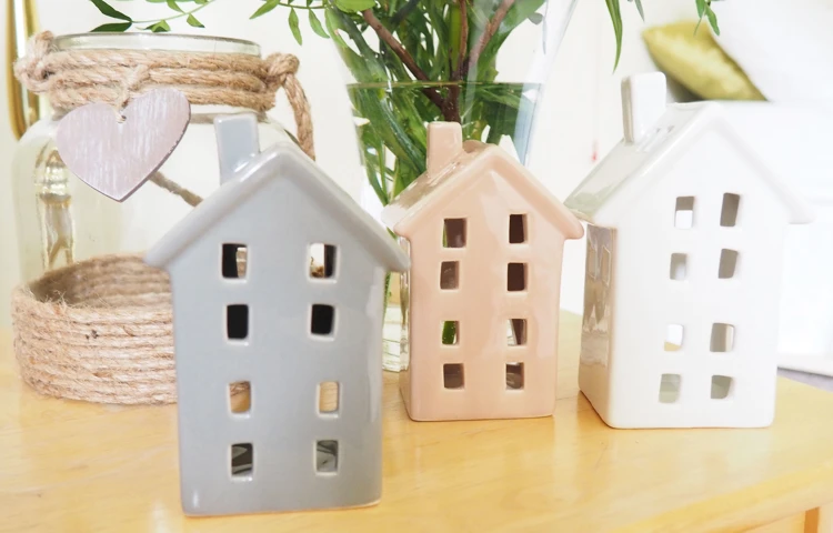 Three house ornaments sat on a cabinet
